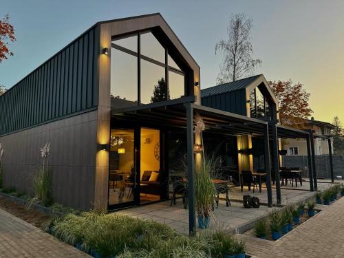 a house with large glass windows and a patio at Triumph Ferienhäuser & Apartments in Rangsdorf