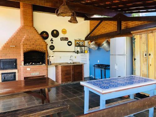 a kitchen with a table and a brick oven at Suite na Casa Azul in Socorro