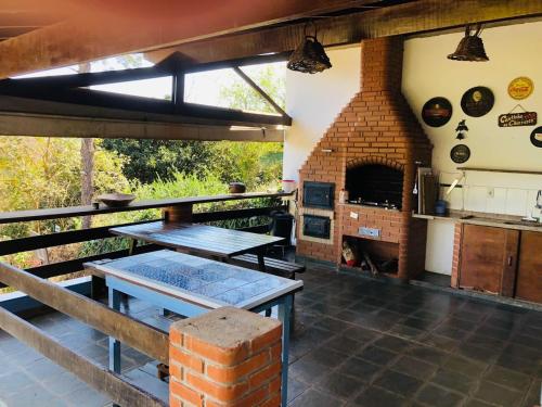 an outdoor kitchen with a table and a brick oven at Suite na Casa Azul in Socorro