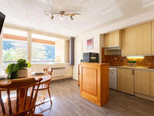 une cuisine avec une table et une salle à manger dans l'établissement Confort au centre de Saint Lary: T3 avec balcon, cuisine équipée - FR-1-296-505, à Saint-Lary-Soulan