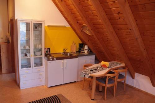 a kitchen with a sink and a table with chairs at Apartment "Karibuni" im Wanderparadies in Sasbachwalden