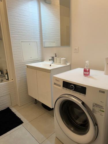une salle de bain avec une machine à laver et un lavabo dans l'établissement Superbe Appartement - Near Paris, à Corbeil-Essonnes