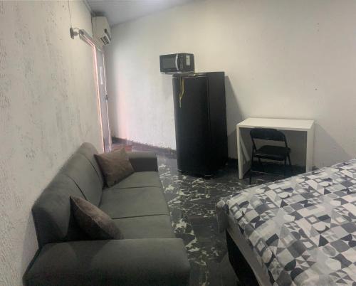 a living room with a couch and a desk at Suíte privada com estacionamento in Boa Vista