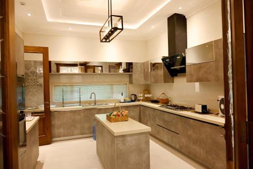 a kitchen with a island in the middle of it at Luxury Spanish Villa Close to Raya Fairways Commercial in Lahore