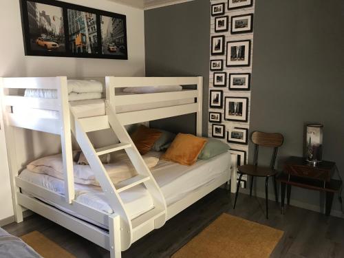 1 dormitorio con 2 literas y escalera en Villa 1950 Détente et Découverte avec spa et piscine extérieure, en Anould