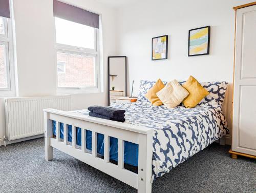 a bedroom with a white bed with blue and white sheets at Central Southsea Guest House in Portsmouth