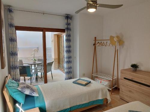 a bedroom with a bed and a dining room with a table at Casa Lily in Caleta De Fuste