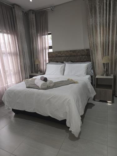 a bedroom with a large bed with towels on it at Executive 2-bedroom Serenity apartment in Wendywood Sandton with its own entrance in Johannesburg