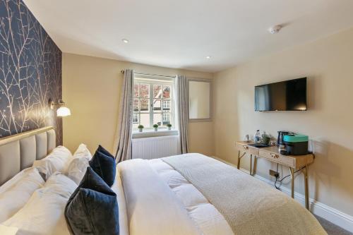 a bedroom with a large bed and a television at The Royal in Wallingford
