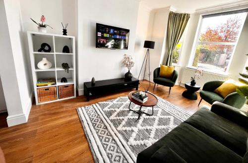 a living room with a couch and a table at Spacious 6 bed house Altrincham in Timperley