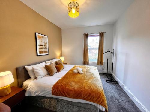 a bedroom with a bed with a teddy bear on it at Spacious 6 bed house Altrincham in Timperley