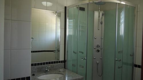 een badkamer met een wastafel en een glazen douche bij Cabañas El Mirador in Hornopiren