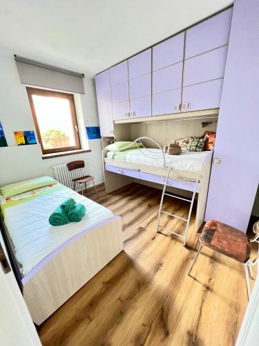 a bedroom with two beds and a window at Condominio Le Dolomiti in Forni di Sotto