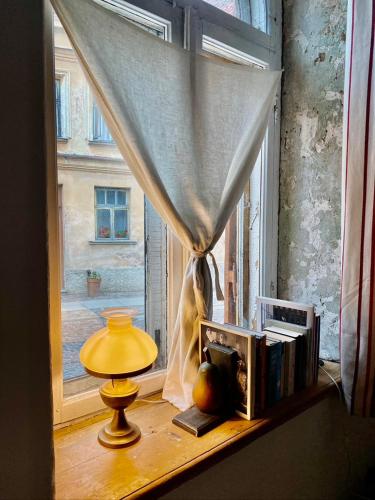 a window with a lamp and books on a window sill at B19 Kuldiga in Kuldīga