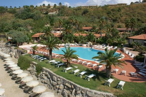 vista aerea su un resort con piscina e sedie a sdraio di Hotel Villaggio Cala Di Volpe a Capo Vaticano