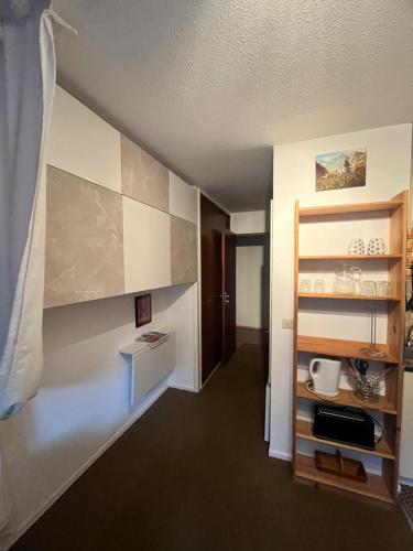 Cette chambre dispose d'un couloir et d'une cuisine avec une étagère. dans l'établissement Emeraude, petit cocon proche des pistes, à Saint-Gervais-les-Bains