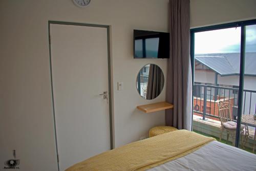 a bedroom with a bed and a mirror and a balcony at 1255 at Ballito Hills Lifestyle Estate in Ballito