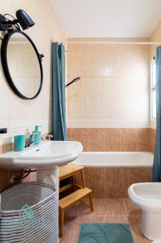 a bathroom with a sink and a tub and a mirror at Villa Pepita in Almerimar