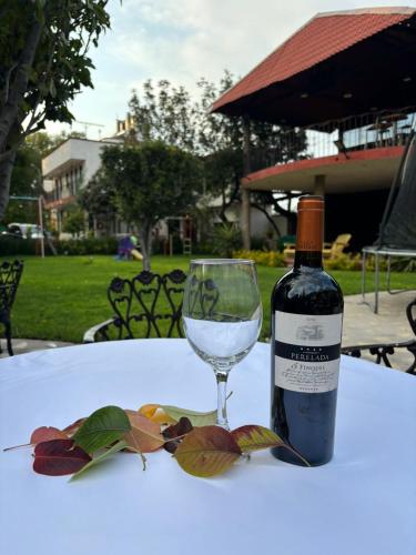 a bottle of wine and a glass on a table at Hotel Real Campestre Tepetoci in Tepexi del Río