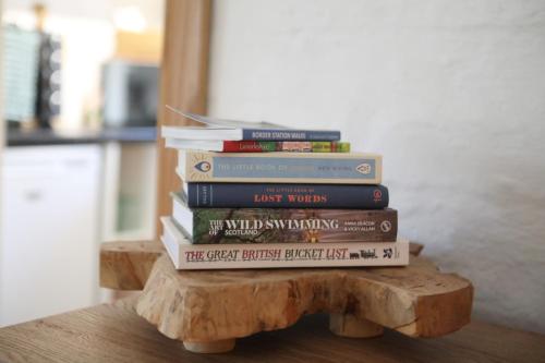 a stack of books sitting on top of a wooden table at Garden Studio in Biggar in Biggar