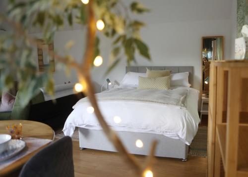 a bedroom with a white bed with christmas lights at Garden Studio in Biggar in Biggar