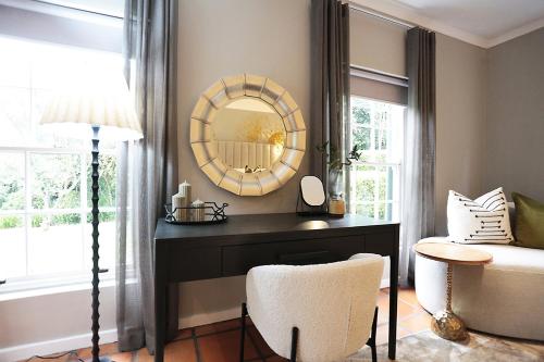 a room with a vanity with a mirror and a chair at Sanddrif Stellenbosch Guest Farm in Stellenbosch