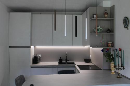 a kitchen with white cabinets and a sink at Condominio Le Dolomiti in Forni di Sotto