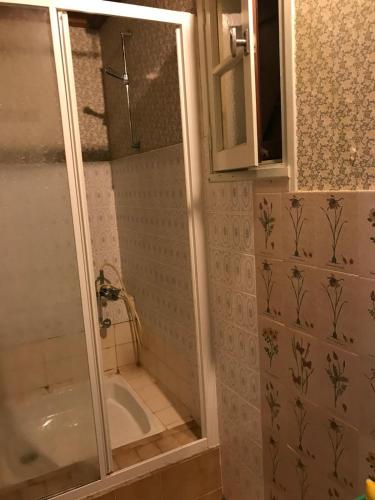 une salle de bain avec une douche avec une porte vitrée dans l'établissement La Petite Maison sur la Colline, à Chassiers