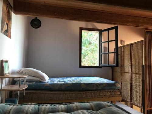 a bedroom with a bed and a window at La Petite Maison sur la Colline in Chassiers