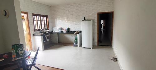 a kitchen with a refrigerator and a counter in a room at Casa praia in Peruíbe