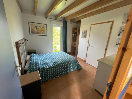 une chambre avec un lit avec une couette bleue dans l'établissement Maison à 300m de la mer, à Trégunc