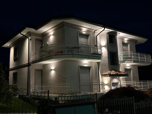 a large white building with a balcony at night at Villa Sofia in Baveno