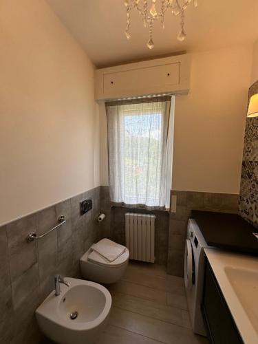 a bathroom with a sink and a toilet and a window at Villa Sofia in Baveno