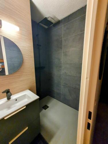 une salle de bain avec un lavabo et une douche dans l'établissement Pléiades , Apt 5 p, 1 grande chambre, un coin montagne et une place de parking , belle vue, à Les Deux Alpes