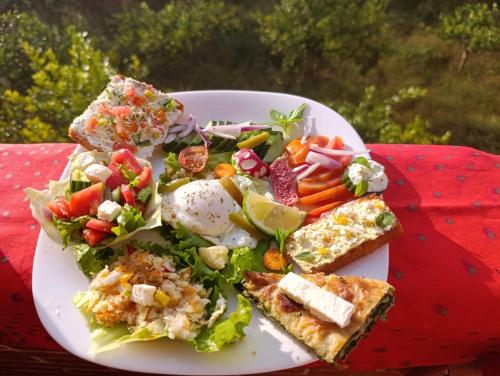 a plate of food with a salad on a table at The Garden Guest House in Divjakë