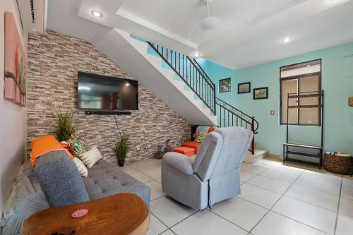 a living room with a couch and a staircase at Villa with Pool, Gated Playas del Coco Getaway in Coco