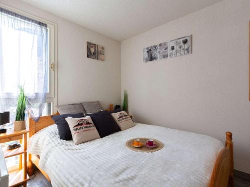 une chambre avec un lit avec un plateau dessus dans l'établissement Confort au centre de Saint Lary: T3 avec balcon, cuisine équipée - FR-1-296-505, à Saint-Lary-Soulan