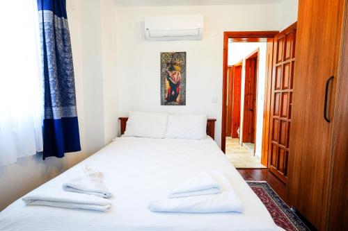 a bedroom with a bed with white sheets at Villa Misli - red/ green in Dalyan