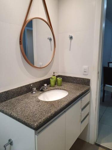 a bathroom counter with a sink and a mirror at Golden Gate Residence Service in Vitória