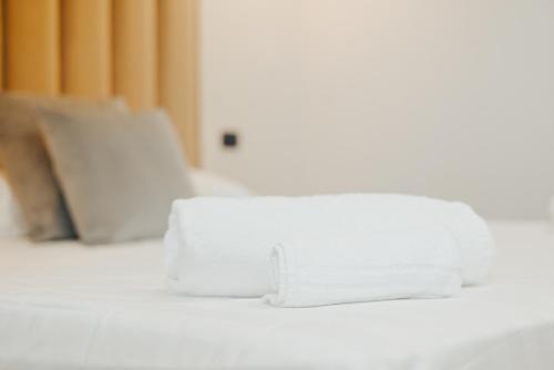 a pile of white towels sitting on top of a bed at Puteoli Palace Hotel in Pozzuoli