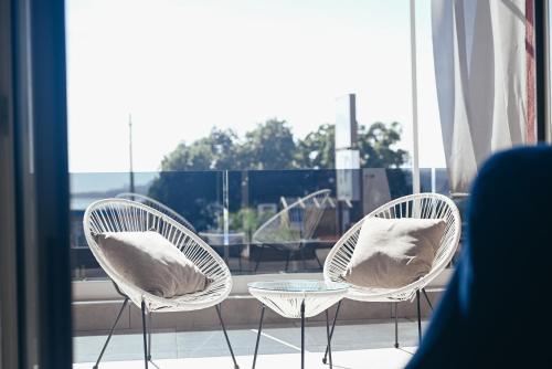 two chairs and a table in front of a window at Puteoli Palace Hotel in Pozzuoli