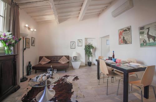 ein Wohnzimmer mit einem Tisch und einem Sofa in der Unterkunft Apartments Florence Pandolfini Roof in Florenz