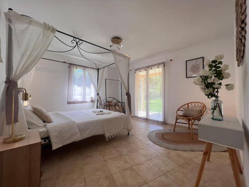 une chambre avec un lit à baldaquin et une chaise dans l'établissement Luxe et charme en Provence, à Draguignan