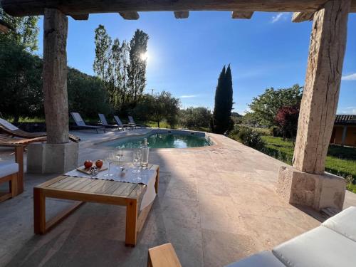 un patio avec une table et une piscine dans l'établissement Luxe et charme en Provence, à Draguignan