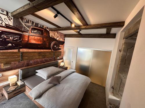 a bedroom with a bed with a painting of a car on the wall at Ateliér Kráľovič in Hokovce