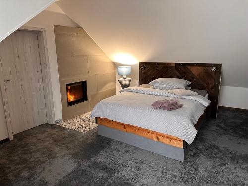 a bedroom with a large bed with a fireplace at Ateliér Kráľovič in Hokovce