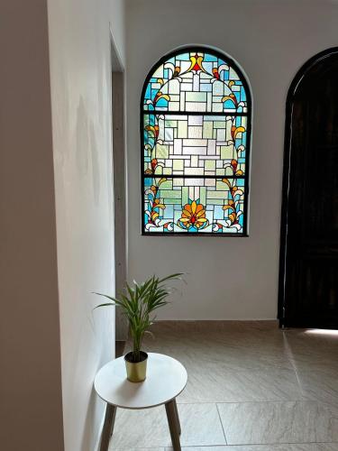 a potted plant sitting on a table in front of a stained glass window at Casa Sileo - boutique Hotel in Cali