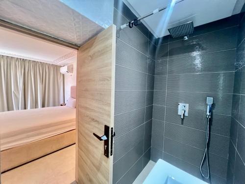 a bathroom with a shower with a toilet and a bed at SABOR FAMILY APARTS -Jaouharat Al Atlas in Marrakech