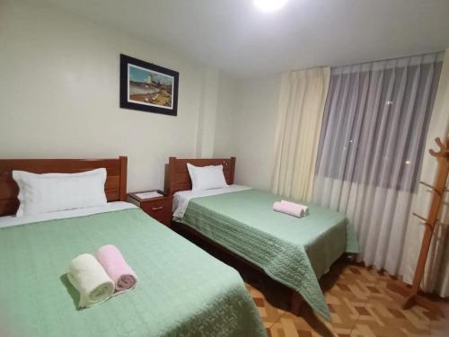 pokój hotelowy z 2 łóżkami i zieloną pościelą w obiekcie Close to Airport - Free One Time Pickup - A y J Familia w mieście Lima