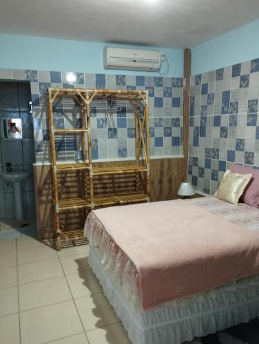 a bedroom with a bed and a window and a sink at Pousada Tycoz Flor do mar in Galinhos